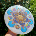 Ce Plateau - Métatron est représenté avec des couleurs spirituelles. Entièrement peint à la main. Rempli de cristal de roche, amazonite, quartz rose, oeil de tigre, améthyste, cornaline, jaspe et métaux... Ce Plateau - Métatron a pour fonction de recharger et de vitaliser vos aliments, vos boissons, vos pierres, bijoux ... Etant diplômée en géobiologie, il a été réalisé par mes soins dans les règles. Il a bénéficié d’un environnement énergétique de hautes vibrations et de mes énergies. Il vous sera utile pour relever le taux vibratoire d’une de vos pièces, pour recharger vos objets, il est aussi un allié contre les ondes électromagnétiques.